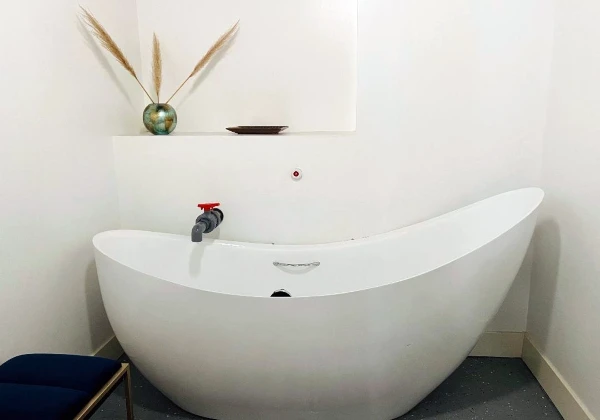 White freestanding immersion tub with a wall-mounted tap in a private Kaqun LA suite