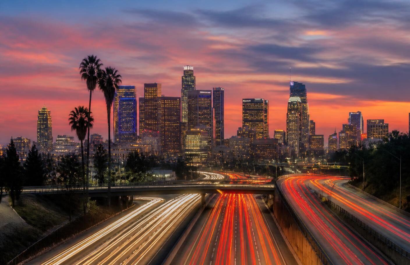 Freeway light trails leading to the Downtown Los Angeles skyline at dusk, the drive-in radius for practices referring patients into the Historic Core