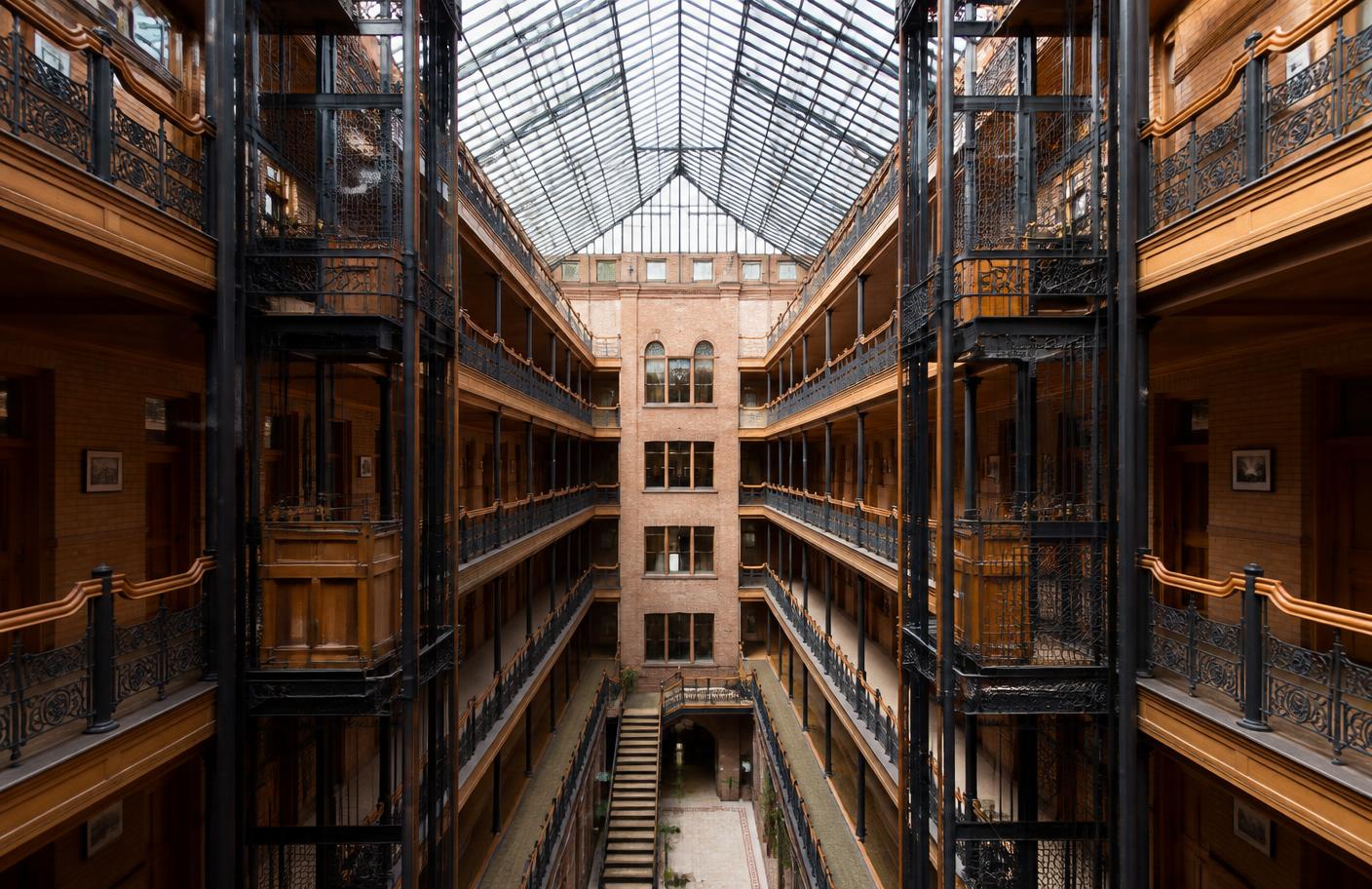 Historic Los Angeles building atrium with open iron elevators and a glass skylight, typical of the practices surrounding the clinic