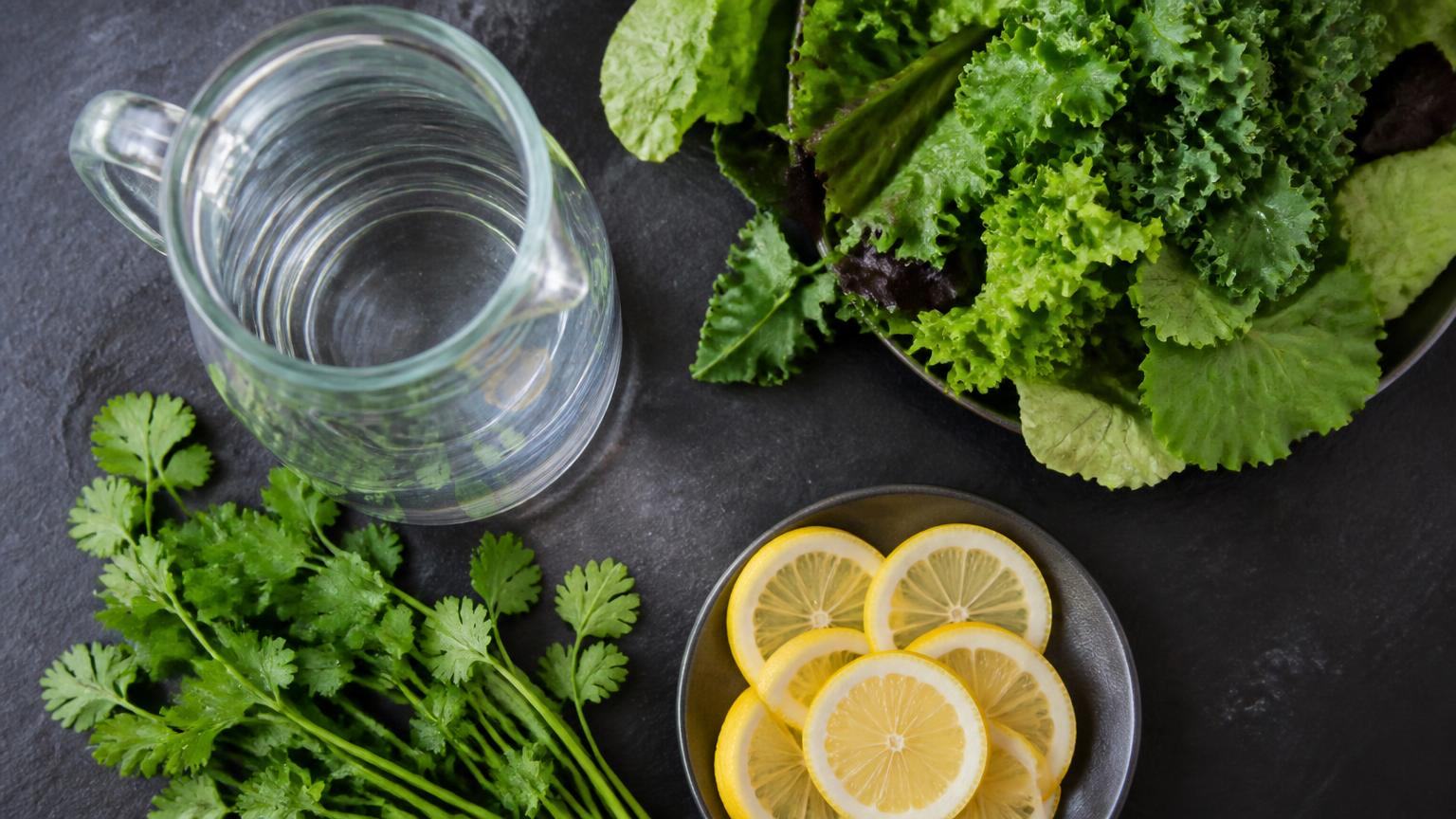 Filtered water, fresh greens, and citrus prepared for a clinical detoxification protocol